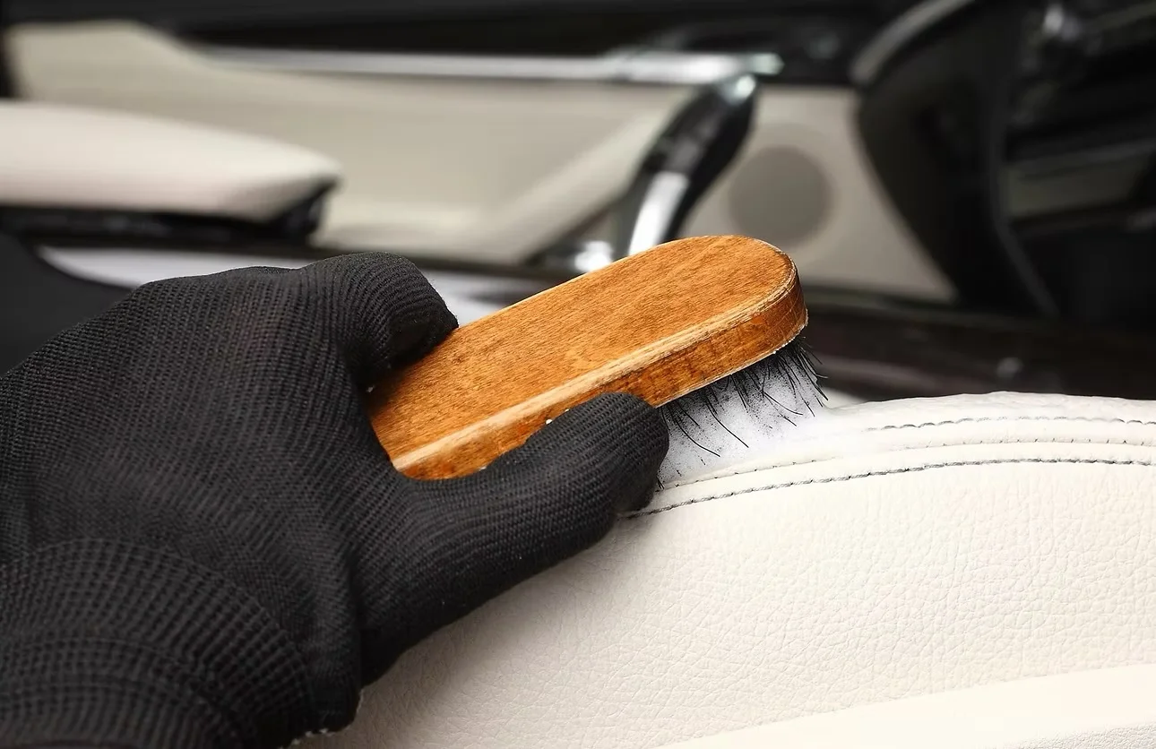 Limpieza de un asiento de cuero claro con cepillo de cerdas suaves