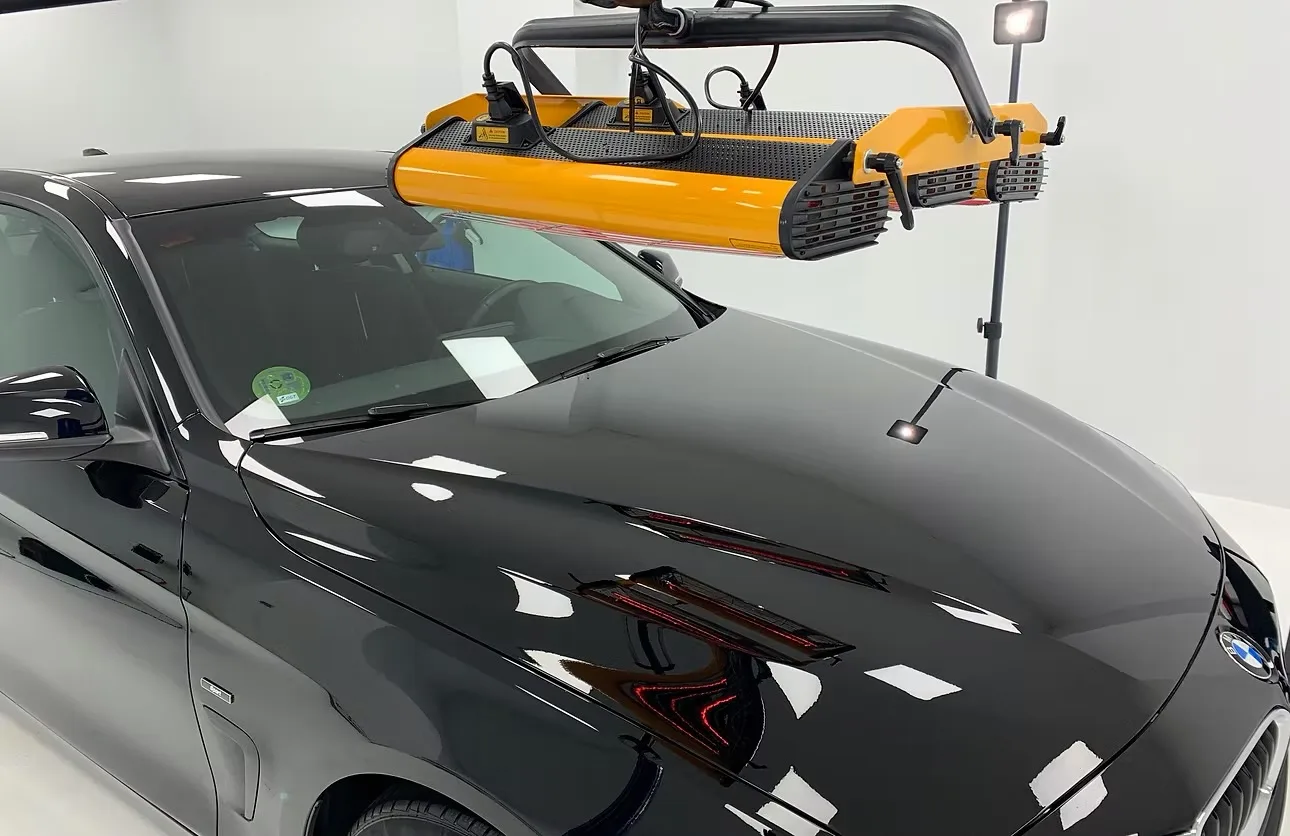 BMW negro recién pulido bajo la lámpara de inspección