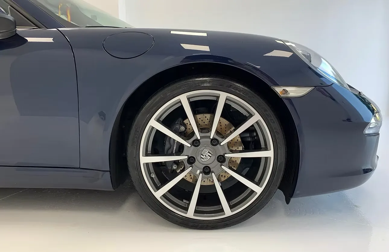 Porsche 911 azul con la llanta recién limpiada